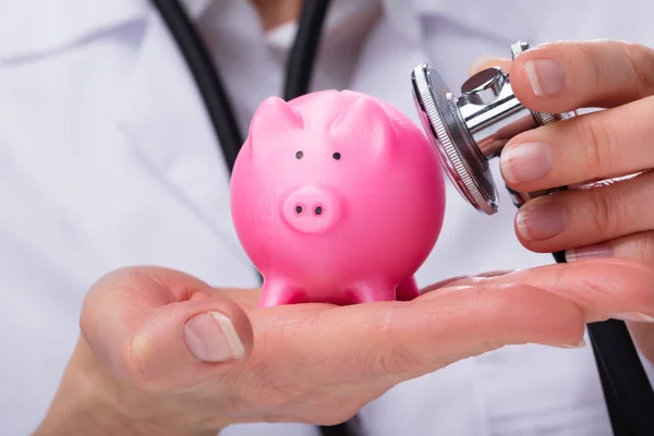 Läkarens Hand Undersöka Rosa Piggybank Med Stetoskop — Stockfoto