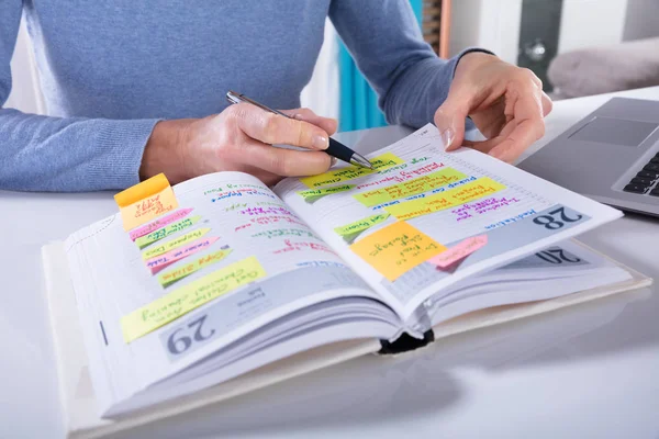 Close Van Een Vrouw Schrijven Schema Kalender Dagboek Witte Bureau — Stockfoto