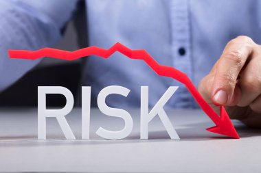 İşadamı Kırmızı Oku Yansıtıcı Masa Üzerinde Risk Metni Üzerine Gösteriyor