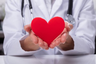 Kırmızı kalp şekli koruyan bir doktorun el Close-Up