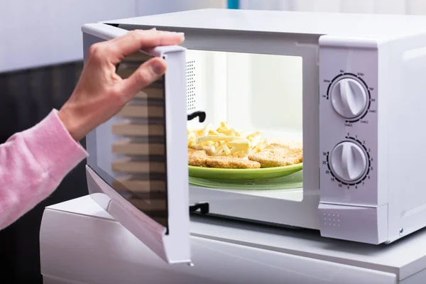 Primo Piano Della Donna Riscaldamento Fritto Alimentare Nel Forno Microonde — Foto Stock