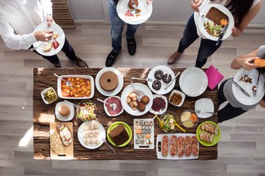 Bir grup insan plaka üzerinde taze sağlıklı yemek yeme