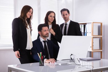 Grup Genç İşadamları işyeri bilgisayar ekranına bakarak