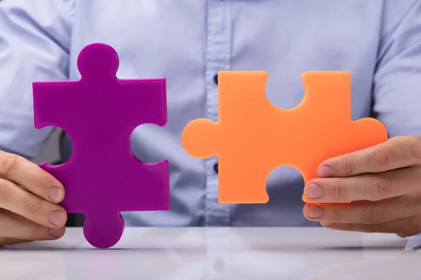 Primer Plano Mano Una Persona Sosteniendo Púrpura Naranja Jigsaw Puzzle — Foto de Stock