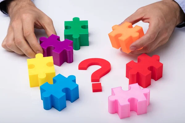 Menselijke Hand Oplossen Van Veelkleurige Puzzel Met Vraagteken Teken Witte — Stockfoto