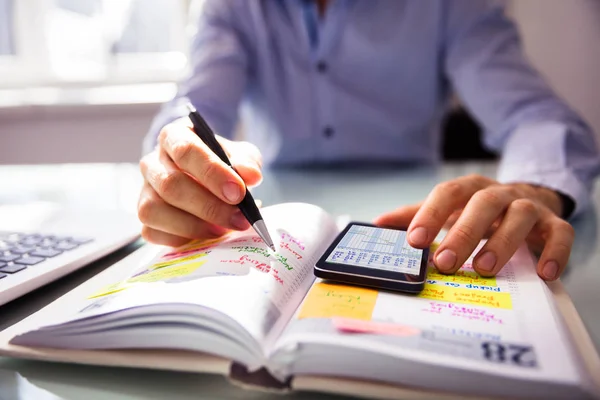 Empresário Usando Telefone Celular Enquanto Escreve Agendamento Diário — Fotografia de Stock