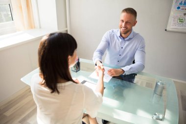 Genç işadamı işyerinde Resepsiyon üzerinde kadın aday ile el sallayarak gülümseyen