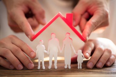 İki kişi aile rakamlar kırmızı ile korunması ahşap Resepsiyon üzerinde çatı