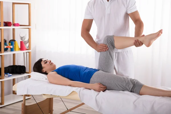 Jovem Mulher Deitada Cama Recebendo Massagem Nas Pernas Pelo Fisioterapeuta — Fotografia de Stock