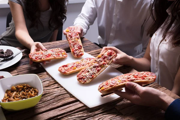 Nahaufnahme Von Freunden Die Bruschetta Über Holztisch Pflücken — Stockfoto