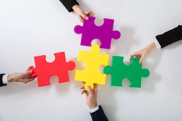 Groep Ondernemers Oplossen Van Puzzel Van Multi Gekleurde Bureau — Stockfoto