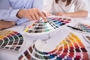 Close-up iki mimarın el planı üzerinde çalışırken çeşitli renkli örneklerini renk seçme