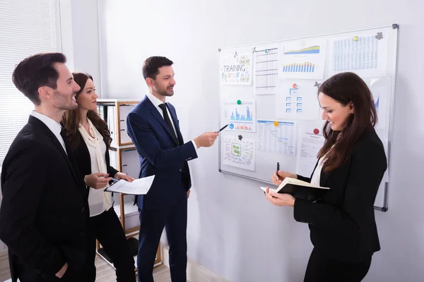 Grupo Jóvenes Empresarios Analizando Gráficos Pizarra Blanca Lugar Trabajo —  Fotos de Stock