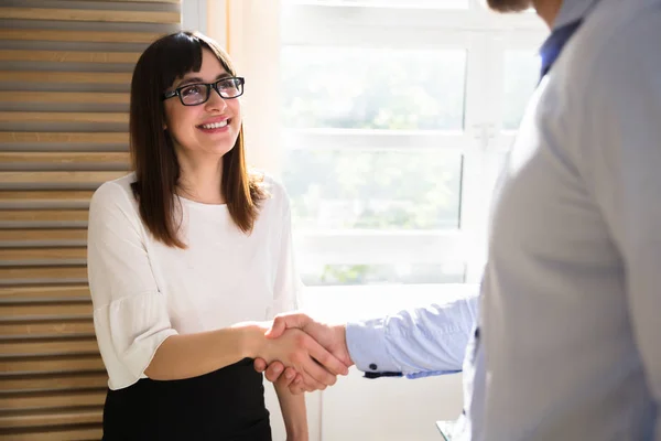 Sonriente Joven Empresaria Estrechando Mano Con Pareja Lugar Trabajo —  Fotos de Stock