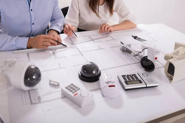 Various Security Equipments Front Two Architects Planning Project Blueprint — Stock Photo, Image
