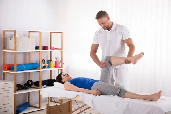 Jovem Fisioterapeuta Masculino Exercício Perna Para Paciente Feminina Spa — Fotografia de Stock