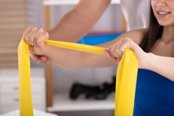Fysiotherapeut Helpen Vrouw Terwijl Het Doen Van Oefening Met Gele — Stockfoto