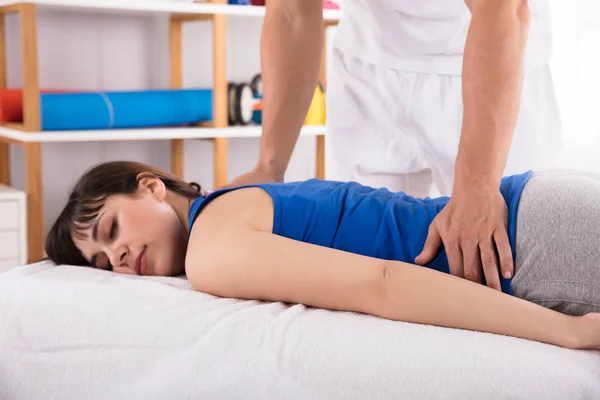 Sjukgymnasts Hand Ger Tillbaka Massage Till Avkopplande Ung Kvinna — Stockfoto