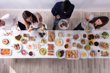 Bir grup insan plaka üzerinde taze sağlıklı yemek yeme