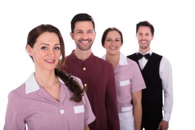 Otel personeli bir satırda ayakta gülümseyen bir grup