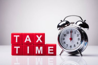 Word'le vergi saat çalar saat yakınındaki yansıtıcı arka plan üzerinde kırmızı küp blokları