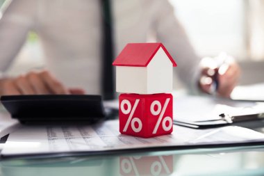 Ev modeli üzerinde işadamının işyerinde çalışan başına yüzde simgesini zarlarla