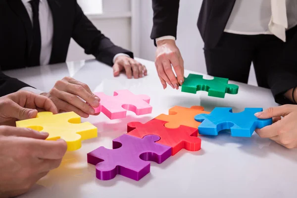 Grupo Empresários Resolvendo Multi Colorido Quebra Cabeça Mesa — Fotografia de Stock