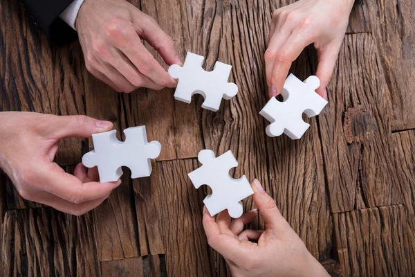 Group Businesspeople Solving Jigsaw Puzzle Desk — Stock Photo, Image