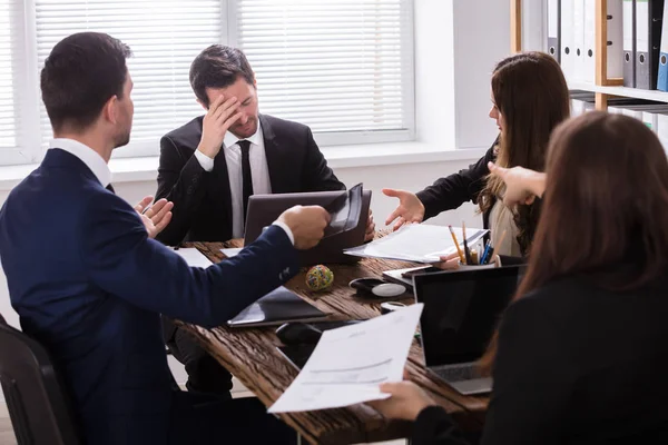 Businesspeople Blaming Depressed Young Male Colleague Workplace — Stock Photo, Image