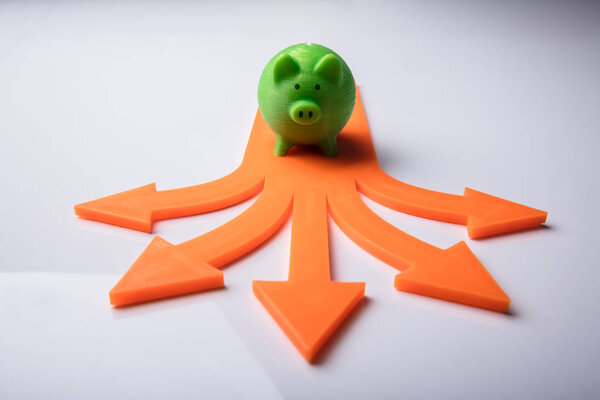 Повышенный вид на Pink Piggybank и голубые стрелки признаки, показывающие различные направления
