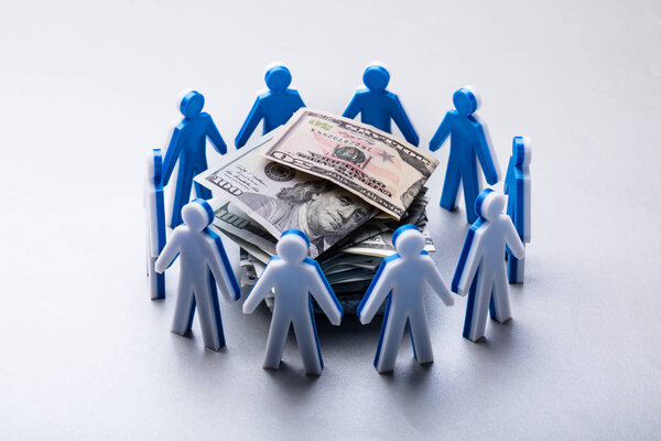 Stacked Banknotes Surrounded By Human Figures Isolated On White Background