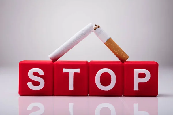 Bloc Cubique Rouge Stop Entouré Cigarettes Cassées Sur Fond Blanc — Photo