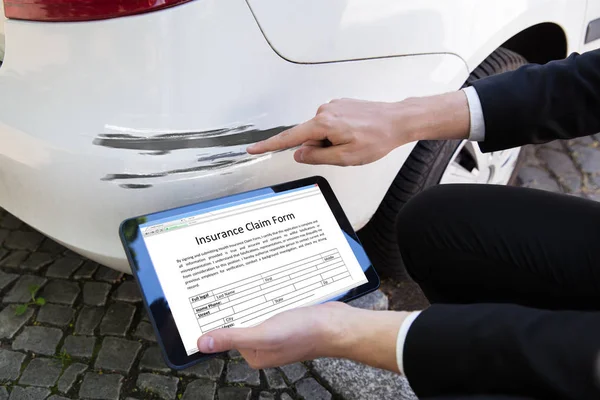 Mão Uma Pessoa Que Examina Carro Danificado Enquanto Preenche Formulário — Fotografia de Stock