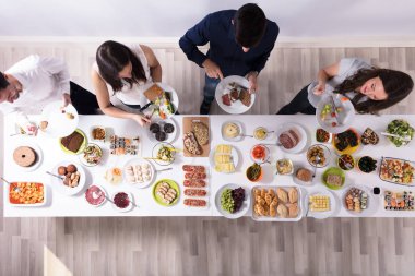Bir grup insan plaka üzerinde taze sağlıklı yemek yeme