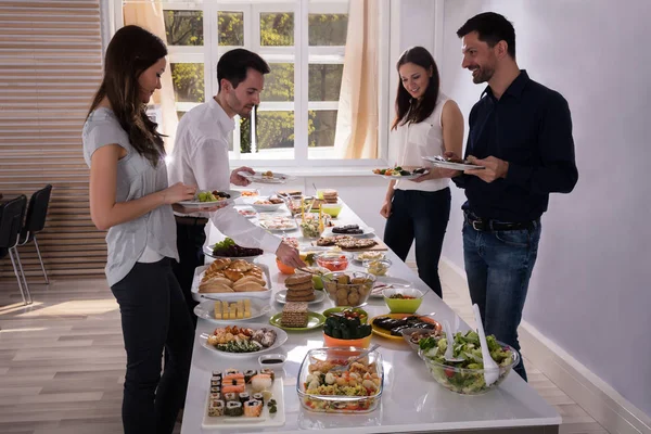 Jovens Amigos Felizes Comendo Comida Deliciosa Servida Mesa — Fotografia de Stock