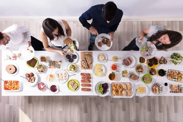 Bir grup insan plaka üzerinde taze sağlıklı yemek yeme