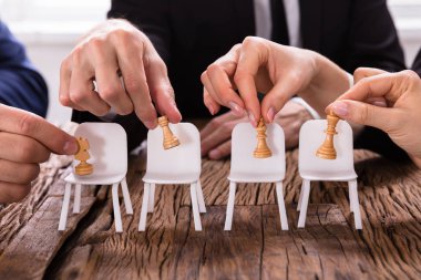 Satranç yerleştirerek bir Businesspersons'ın elleri Close-up sandalyelere rakamlar