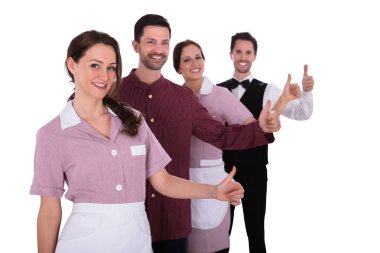 Otel personeli bir satırda ayakta gülümseyen bir grup