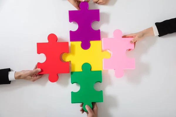 Gruppe Von Geschäftsleuten Löst Buntes Puzzle Auf Schreibtisch — Stockfoto