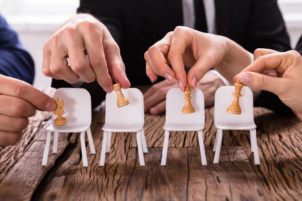 Satranç yerleştirerek bir Businesspersons'ın elleri Close-up sandalyelere rakamlar