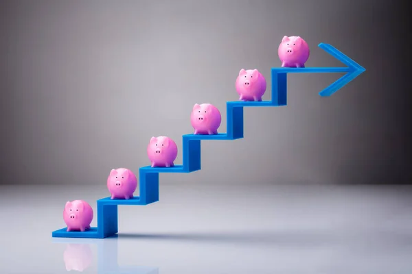 Vele Roze Piggybanks Het Vergroten Van Blauwe Pijl Stappen Tegen — Stockfoto