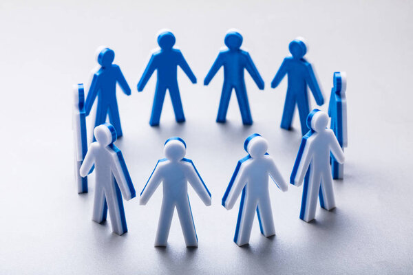 Крупный план человеческих фигур, образующих круг, стоящий на белом фоне
