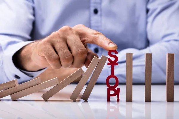 Menselijke Vinger Voorbij Risico Word Dominos Stoppen Vallen Bureau — Stockfoto