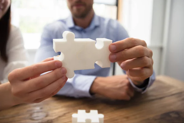 Close Dois Empresários Peças Quebra Cabeça Branco Sobre Mesa Madeira — Fotografia de Stock