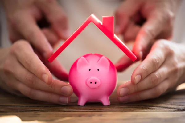 Close Two People Protecting Pink Piggybank Red Roof — Stock Photo, Image