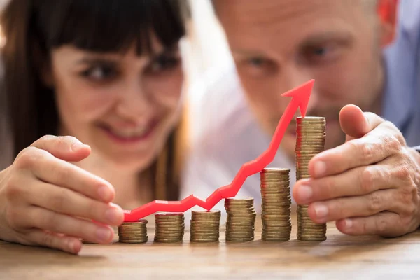 Pareja Feliz Proteger Aumento Monedas Apiladas Con Flecha Roja —  Fotos de Stock