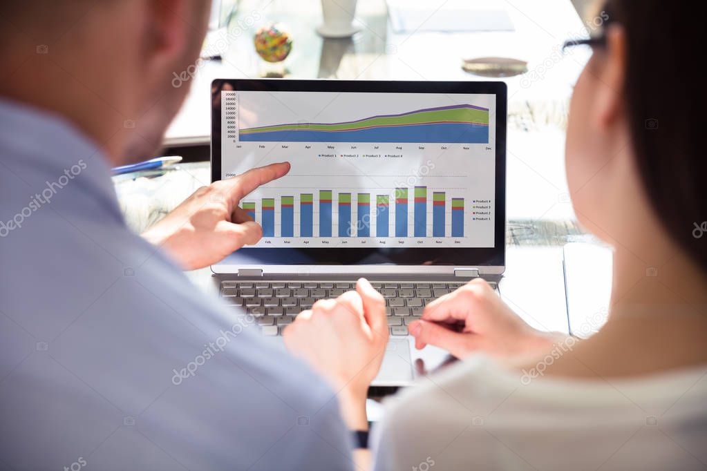 Close-up Of Two Businesspeople Analyzing Graph On Laptop
