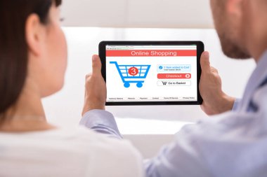 Bir çiftin el Online dijital Tablet üzerinde alışveriş yakın çekim