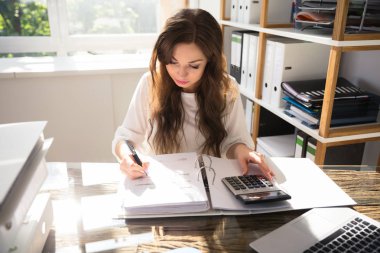 Genç işkadını Bill Office hesap makinesiyle hesaplama