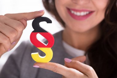 Close-up Of A Woman Holding Paragraph Symbol Painted With German Flag clipart